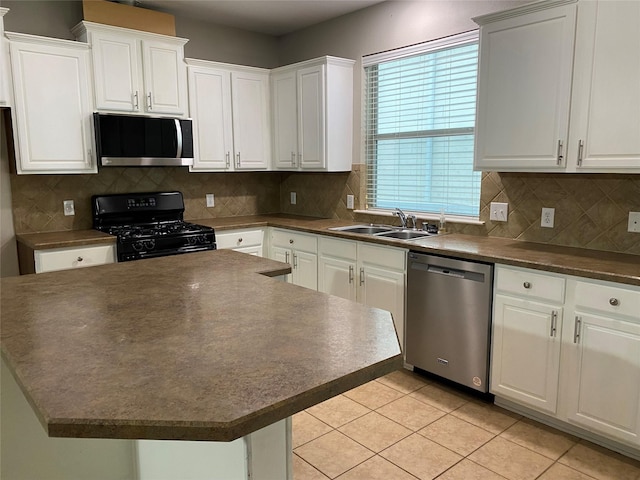 1705 Spanish Moss Way, Savannah, TX 76227 - kitchen with appliances with stainless steel finishes, a sink, dark countertops, white cabinetry, and a center island