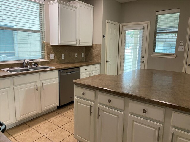 1705 Spanish Moss Way, Savannah, TX 76227 - kitchen with dishwasher, a sink, dark countertops, light tile patterned floors, and decorative backsplash