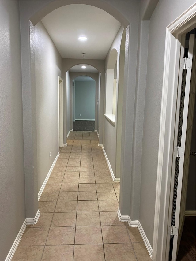 1705 Spanish Moss Way, Savannah, TX 76227 - corridor featuring arched walkways, light tile patterned flooring, and baseboards