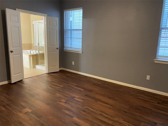1705 Spanish Moss Way, Savannah, TX 76227 - unfurnished bedroom with dark wood-style flooring, baseboards, and ensuite bathroom