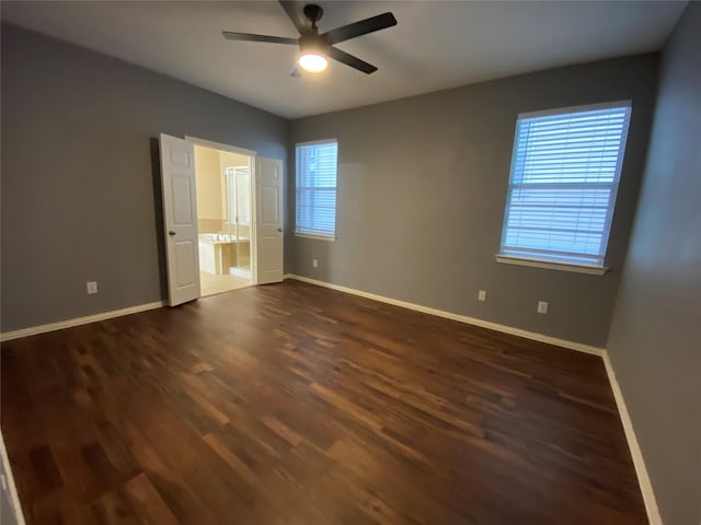 1705 Spanish Moss Way, Savannah, TX 76227 - unfurnished bedroom featuring dark wood-style floors, baseboards, ensuite bathroom, and a ceiling fan