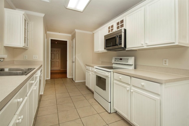 4512 Blue Jay Ln, Sherman, TX 75092 - kitchen featuring electric stove, stainless steel microwave, light tile patterned floors, a sink, and ornamental molding