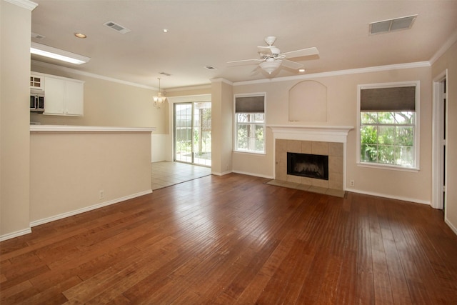 4512 Blue Jay Ln, Sherman, TX 75092 - unfurnished living room with plenty of natural light, hardwood / wood-style floors, a tile fireplace, a chandelier, and ornamental molding