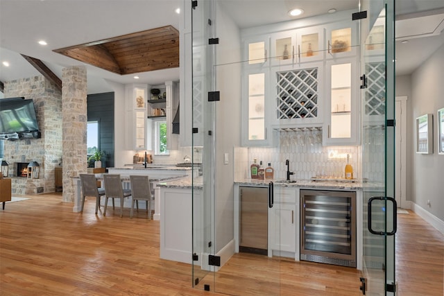 18280 Red Oak Dr, Mabank, TX 75156 - indoor wet bar featuring wine cooler, lofted ceiling, light wood finished floors, tasteful backsplash, and recessed lighting