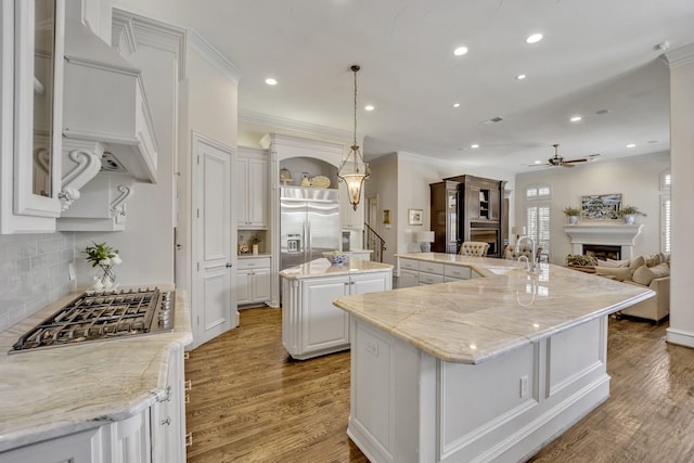 1516 Byron Nelson Pkwy, Southlake, TX 76092 - kitchen with stainless steel appliances, a large island with sink, ceiling fan, light wood-style floors, and recessed lighting