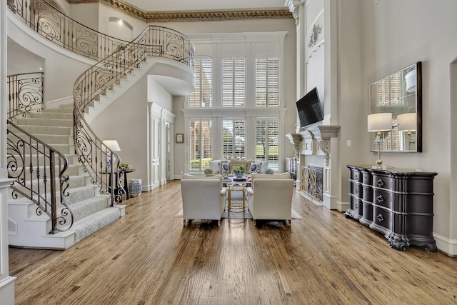 1516 Byron Nelson Pkwy, Southlake, TX 76092 - living area with a towering ceiling, a glass covered fireplace, wood finished floors, baseboards, and crown molding