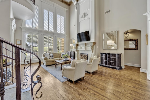 1516 Byron Nelson Pkwy, Southlake, TX 76092 - living room featuring a towering ceiling, wood finished floors, a fireplace, baseboards, and arched walkways
