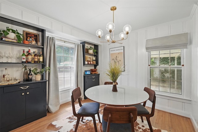 916 Carondolet Ct, River Oaks, TX 76114 - dining room featuring a decorative wall, light wood-style floors, a chandelier, a bar, and crown molding
