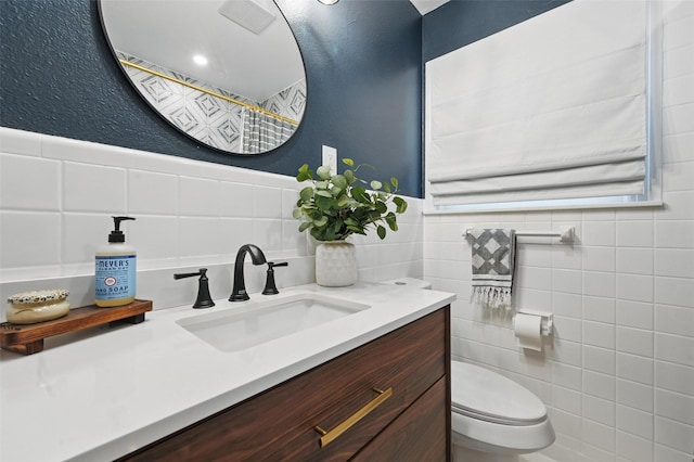 916 Carondolet Ct, River Oaks, TX 76114 - bathroom with vanity, toilet, tile walls, a textured wall, and wainscoting