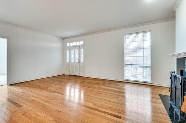 3208 Cole Ave Unit 2205, Dallas, TX 75204 - unfurnished living room with ornamental molding, a fireplace with flush hearth, light wood-style flooring, and baseboards