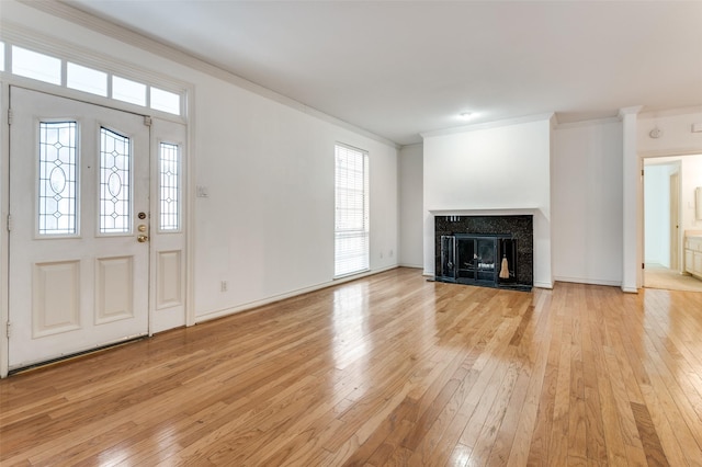 3208 Cole Ave Unit 2205, Dallas, TX 75204 - unfurnished living room featuring crown molding, light wood-style floors, baseboards, and a high end fireplace