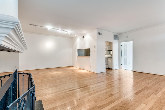 3208 Cole Ave Unit 2205, Dallas, TX 75204 - unfurnished living room with light wood finished floors, crown molding, and rail lighting