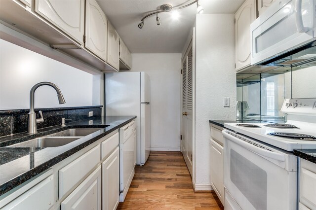 3208 Cole Ave Unit 2205, Dallas, TX 75204 - kitchen with white appliances, a sink, light wood finished floors, and white cabinetry