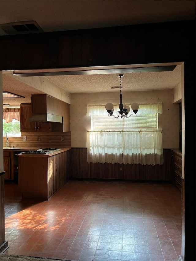 425 Ten Mile Dr, Desoto, TX 75115 - unfurnished dining area with a chandelier, wainscoting, wood walls, a textured ceiling, and a sink