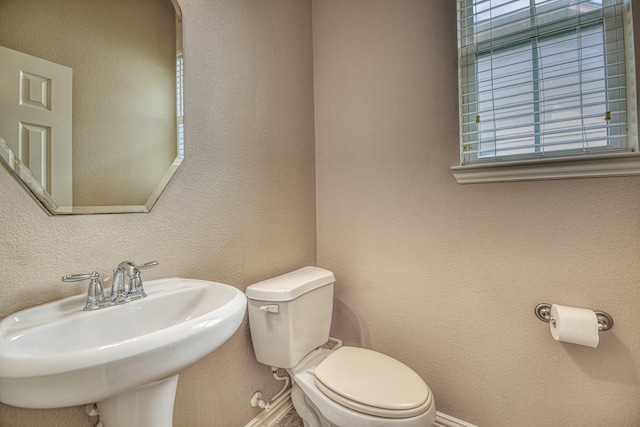 6939 Truth Dr, Dallas, TX 75236 - bathroom featuring a sink, toilet, baseboards, and a textured wall