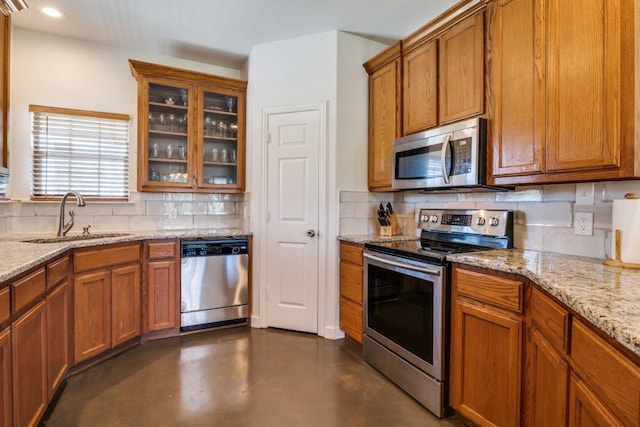 1759 County Road 2712, Caddo Mills, TX 75135 - kitchen with appliances with stainless steel finishes, a sink, tasteful backsplash, brown cabinets, and light stone countertops