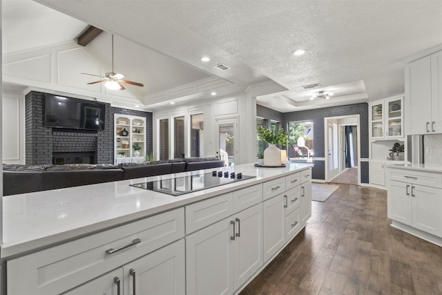 517 Sunset Dr, Hurst, TX 76054 - kitchen with black electric cooktop, a ceiling fan, light countertops, dark wood-style floors, and a textured ceiling