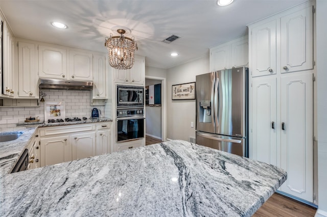 1913 Windlea Dr, Euless, TX 76040 - kitchen with black appliances, under cabinet range hood, decorative backsplash, light stone counters, and white cabinetry