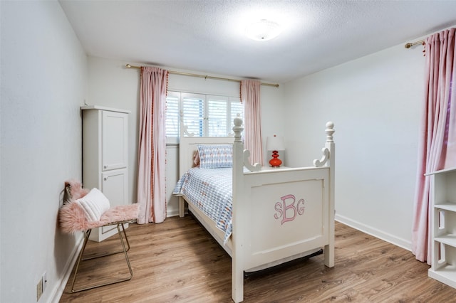 1913 Windlea Dr, Euless, TX 76040 - bedroom with wood finished floors, a textured ceiling, and baseboards