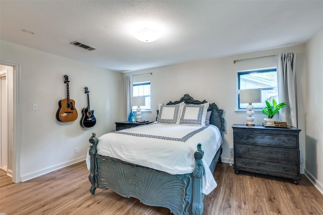 1913 Windlea Dr, Euless, TX 76040 - bedroom featuring wood finished floors, baseboards, and a textured ceiling