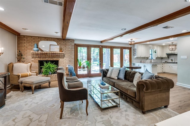 1913 Windlea Dr, Euless, TX 76040 - living room featuring beam ceiling, light wood-style flooring, a fireplace, a chandelier, and recessed lighting