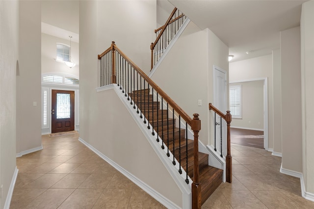 5505 Wisdom Ct, Waco, TX 76708 - staircase featuring healthy amount of natural light, tile patterned flooring, a high ceiling, and baseboards