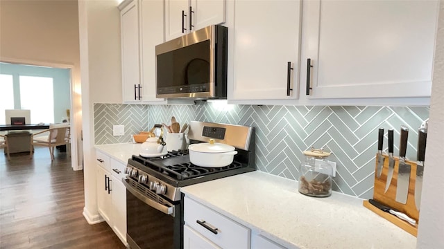 1605 Anacua Ln, Wylie, TX 75098 - kitchen featuring appliances with stainless steel finishes, tasteful backsplash, dark wood-style floors, white cabinets, and light stone countertops