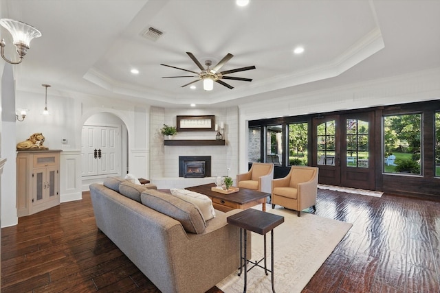 1208 Chandler Cir, Prosper, TX 75078 - living room with a tray ceiling, a fireplace, ceiling fan, recessed lighting, and arched walkways