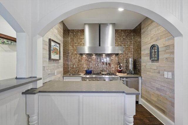 1208 Chandler Cir, Prosper, TX 75078 - kitchen featuring wall chimney range hood, wood walls, white cabinets, dark wood finished floors, and range