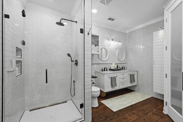 1208 Chandler Cir, Prosper, TX 75078 - bathroom featuring a shower stall, double vanity, ornamental molding, tile walls, and wood finished floors