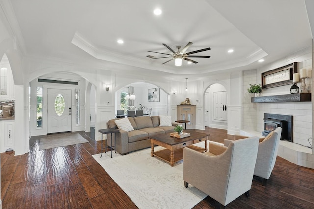 1208 Chandler Cir, Prosper, TX 75078 - living room with a raised ceiling, arched walkways, a ceiling fan, ornamental molding, and a decorative wall