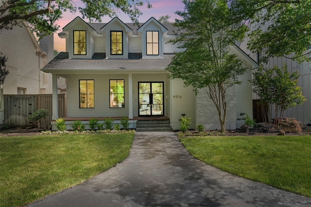 4516 Shenandoah Ave, University Park, TX 75205 - view of front of house with roof with shingles, brick siding, a porch, and a lawn