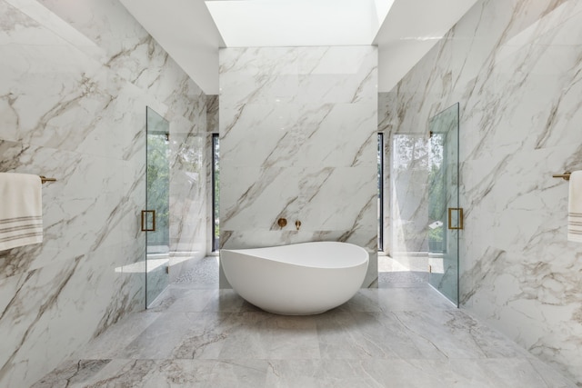 2031 Cullen Ave, Dallas, TX 75206 - bathroom featuring a freestanding bath, a marble finish shower, marble tiled flooring, and stone wall