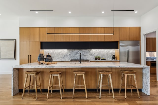 2031 Cullen Ave, Dallas, TX 75206 - kitchen with built in fridge, a sink, a spacious island, decorative backsplash, and light stone counters