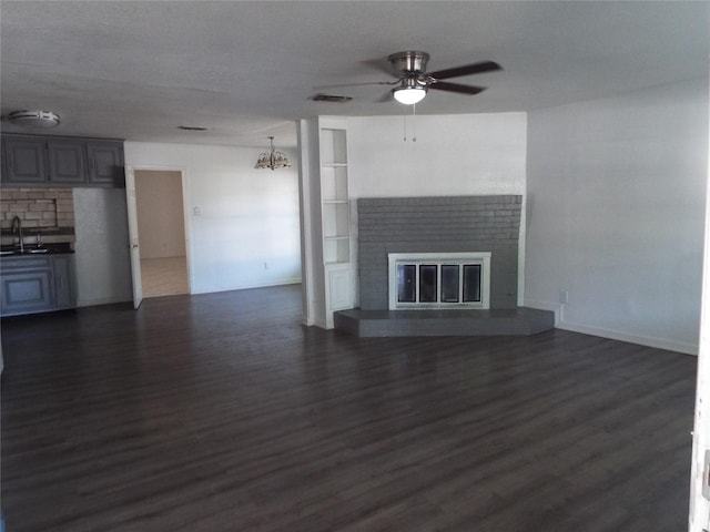337 W Coral Way, Grand Prairie, TX 75051 - unfurnished living room with a sink, ceiling fan, dark wood-type flooring, and a fireplace