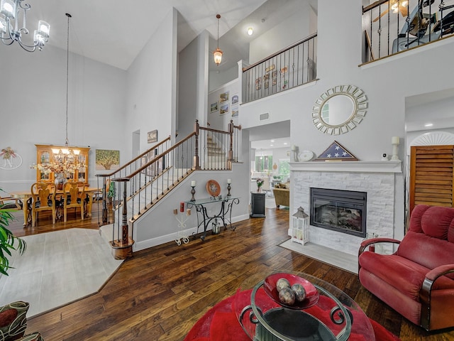 525 Sir Roland Dr, Grand Prairie, TX 75052 - living room featuring a chandelier, stairs, a towering ceiling, hardwood / wood-style floors, and a stone fireplace