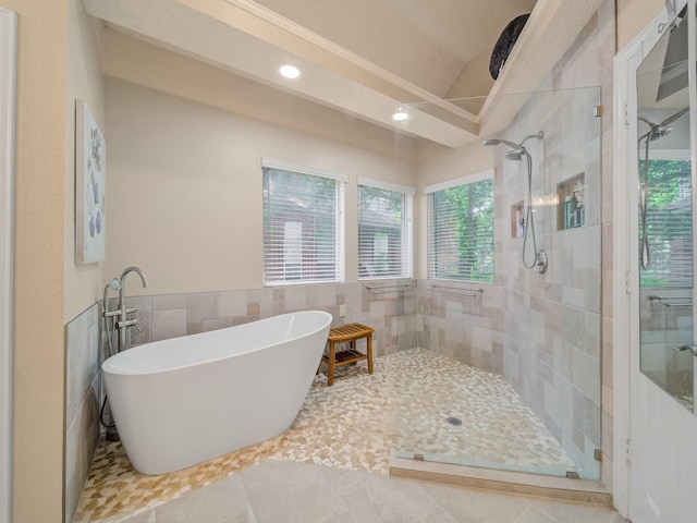 525 Sir Roland Dr, Grand Prairie, TX 75052 - bathroom with a freestanding bath, a tile shower, tile walls, recessed lighting, and tile patterned flooring