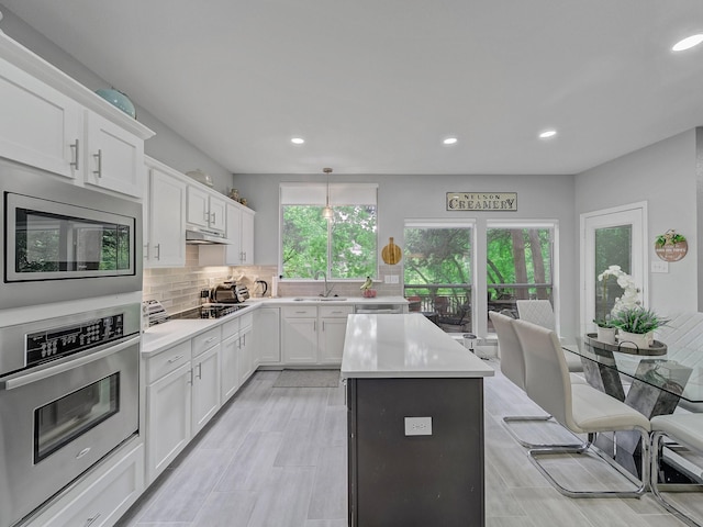 525 Sir Roland Dr, Grand Prairie, TX 75052 - kitchen featuring appliances with stainless steel finishes, a sink, recessed lighting, light countertops, and a center island