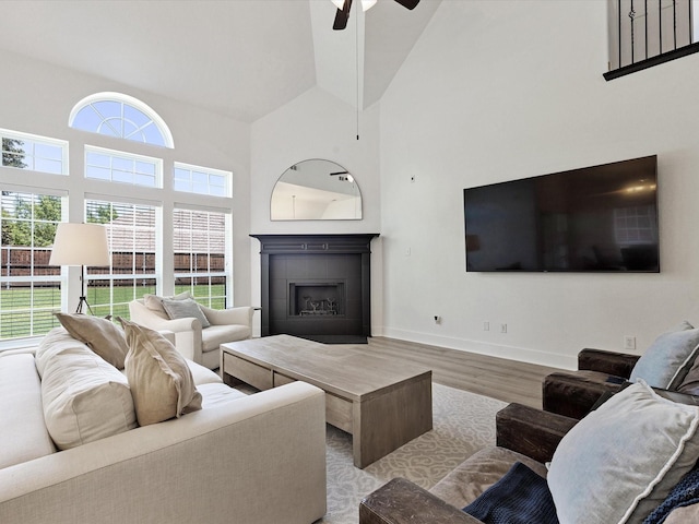 2231 Cold Water Dr, Prosper, TX 75078 - living area featuring high vaulted ceiling, wood finished floors, ceiling fan, a tile fireplace, and baseboards