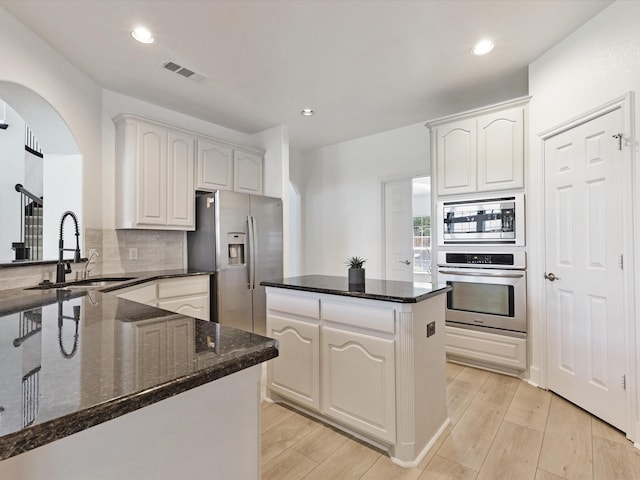 2231 Cold Water Dr, Prosper, TX 75078 - kitchen with stainless steel appliances, a sink, dark stone countertops, a kitchen island, and tasteful backsplash