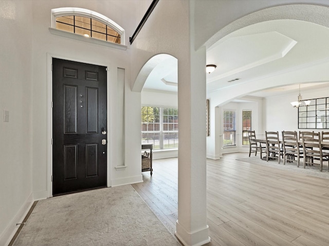 2231 Cold Water Dr, Prosper, TX 75078 - foyer with arched walkways, wood finished floors, a chandelier, and baseboards