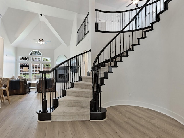 2231 Cold Water Dr, Prosper, TX 75078 - stairway featuring a ceiling fan, high vaulted ceiling, wood finished floors, and baseboards