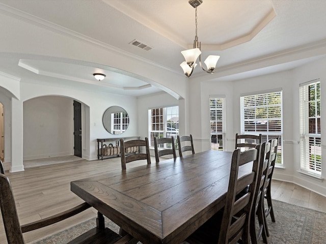 2231 Cold Water Dr, Prosper, TX 75078 - dining room with a raised ceiling, arched walkways, a chandelier, light wood finished floors, and healthy amount of natural light
