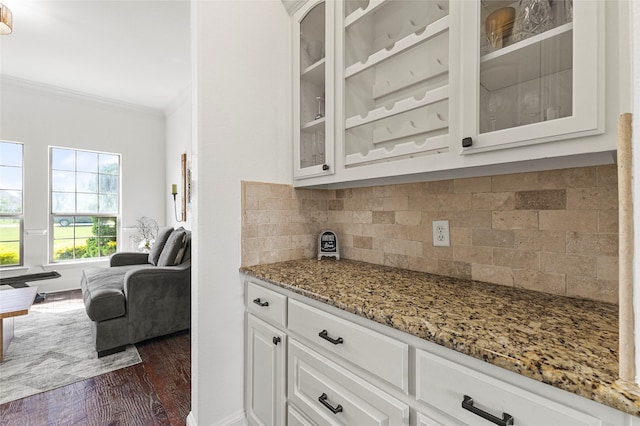 204 Lost Spur Ln, Royse City, TX 75189 - kitchen with crown molding, light stone counters, dark wood-style flooring, glass insert cabinets, and decorative backsplash