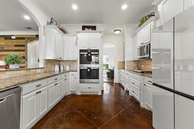 204 Lost Spur Ln, Royse City, TX 75189 - kitchen with stainless steel appliances, arched walkways, light stone counters, tasteful backsplash, and crown molding