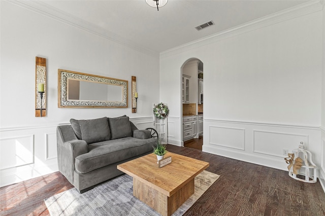 204 Lost Spur Ln, Royse City, TX 75189 - living room featuring crown molding, arched walkways, wood finished floors, a decorative wall, and a wainscoted wall