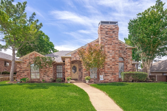 2332 Heatherwoods Way, Carrollton, TX 75007 - view of front of home with a front lawn, brick siding, a chimney, and roof with shingles