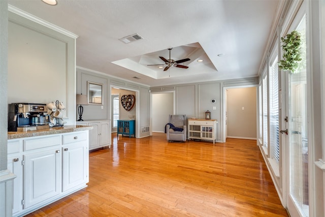 2332 Heatherwoods Way, Carrollton, TX 75007 - living area with a raised ceiling, crown molding, light wood finished floors, a ceiling fan, and baseboards