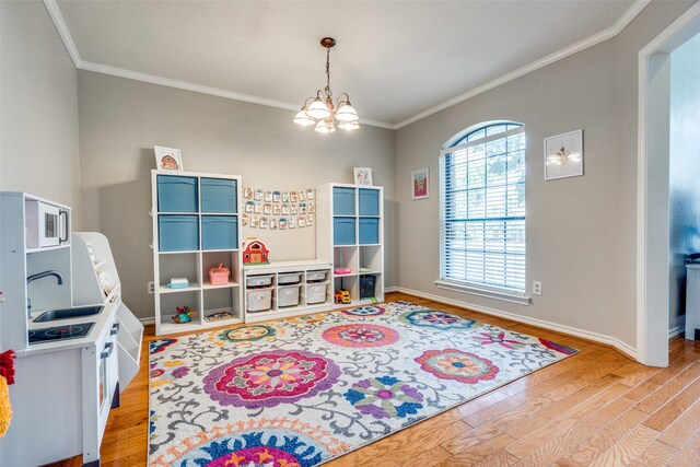 2332 Heatherwoods Way, Carrollton, TX 75007 - recreation room with light wood-style flooring, a sink, crown molding, a chandelier, and baseboards