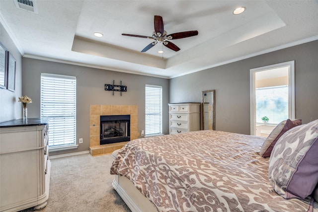 2332 Heatherwoods Way, Carrollton, TX 75007 - carpeted bedroom with a raised ceiling, ornamental molding, a tile fireplace, recessed lighting, and a ceiling fan